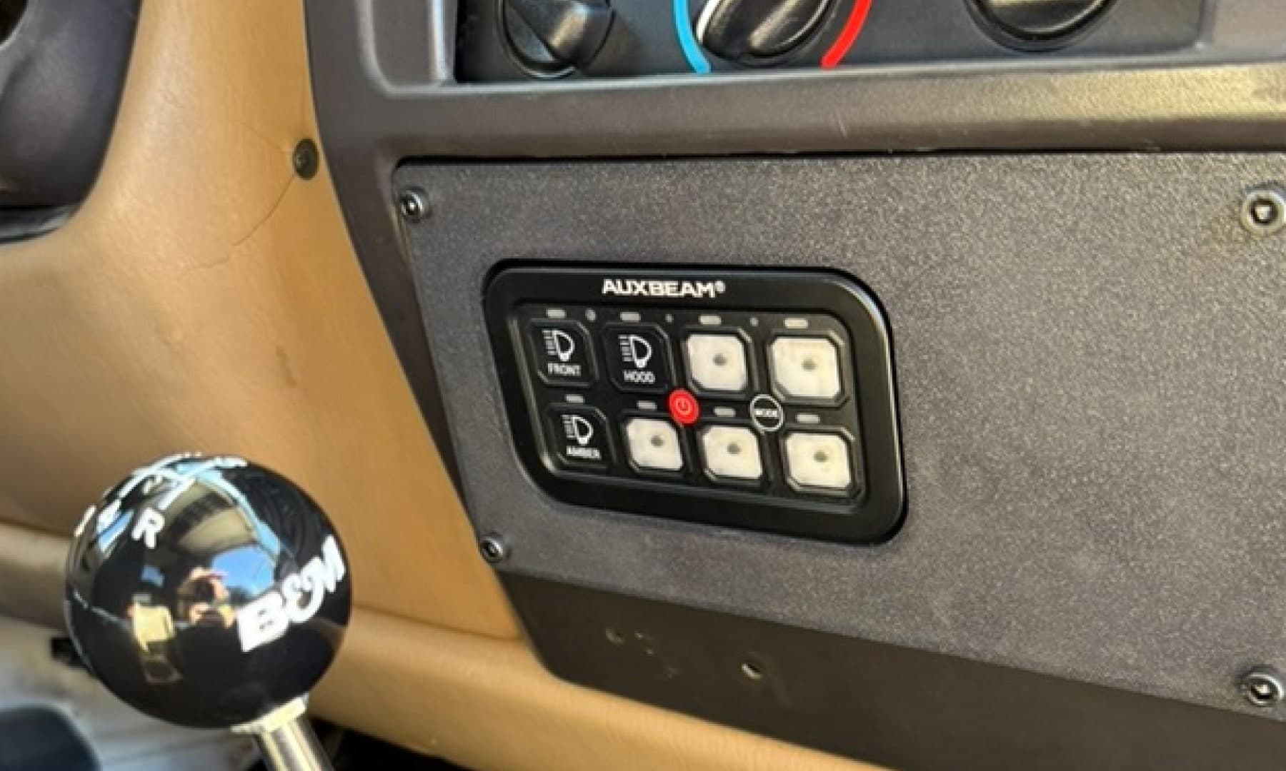 Interior of a Jeep TJ showing an Auxbeam controller inside of the switch control panel