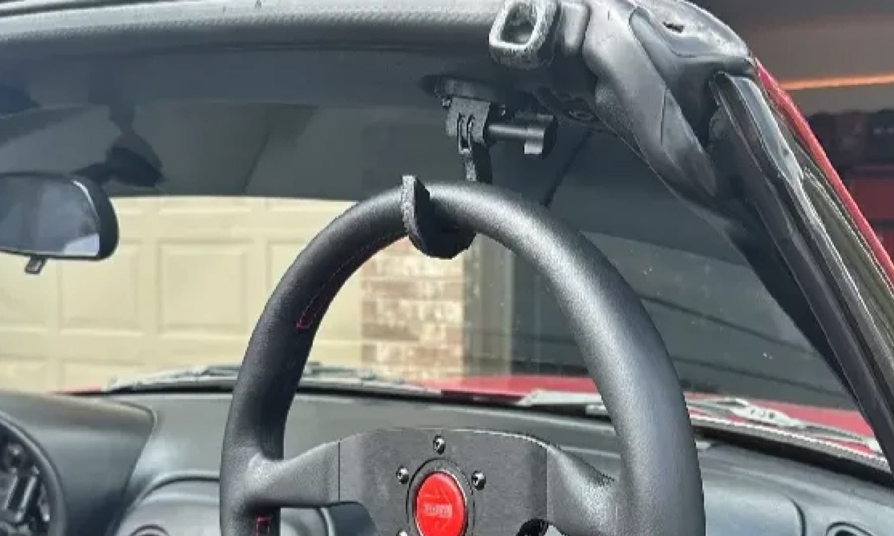 Miata interior with a bracket holding a steering wheel