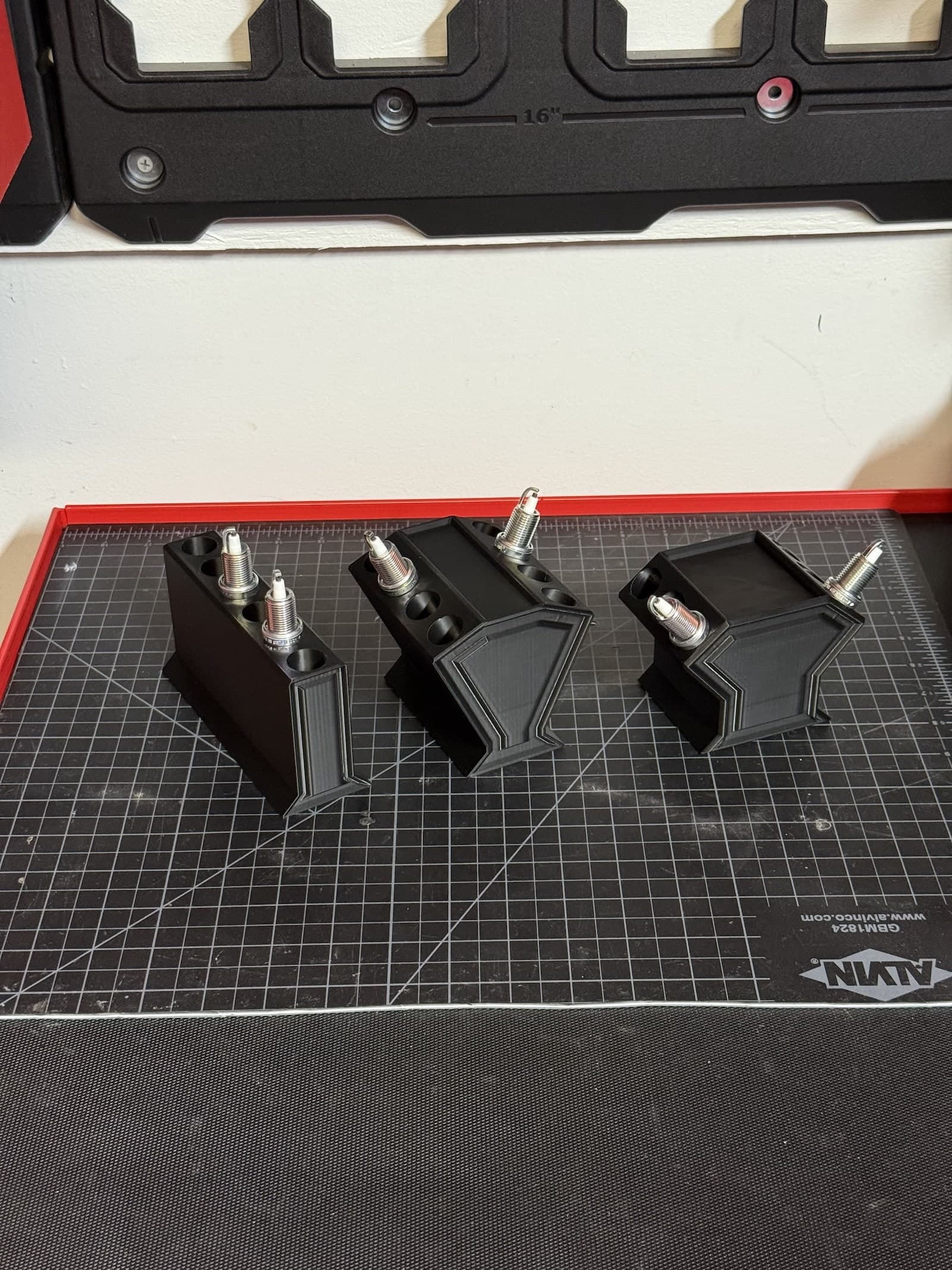 Three example plastic engine shape spark plug holders